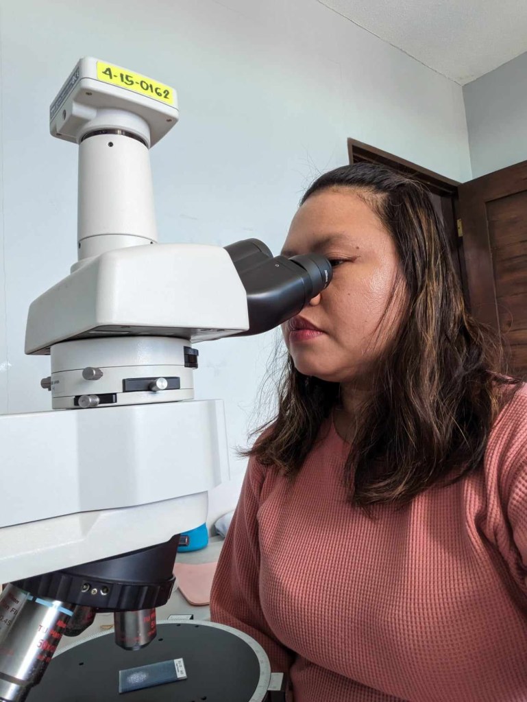 scientist Grass analyzing a sample under the microscope